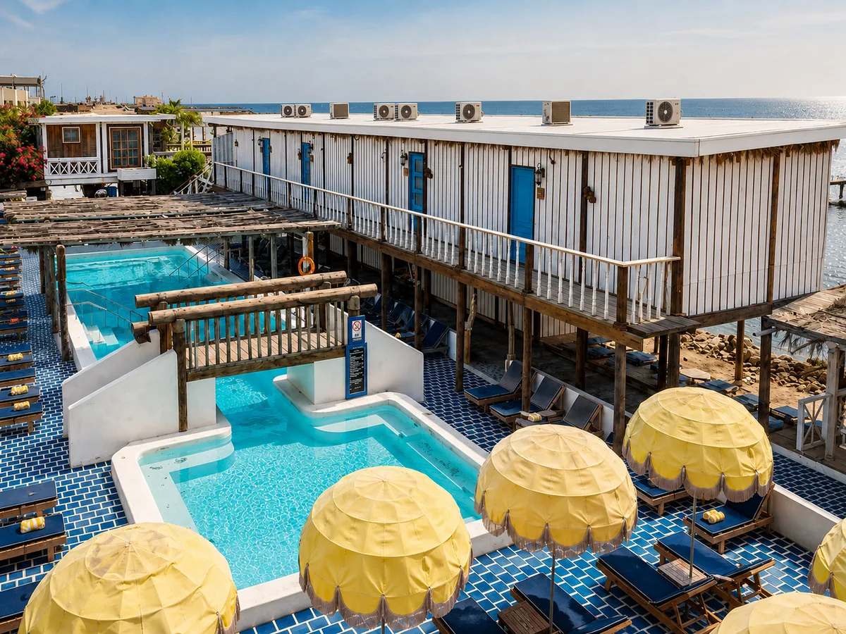 Daytime aerial of pools and resort with yellow umbrellas